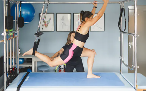 Aluna em aparelho de pilates com acompanhamento no Átrio